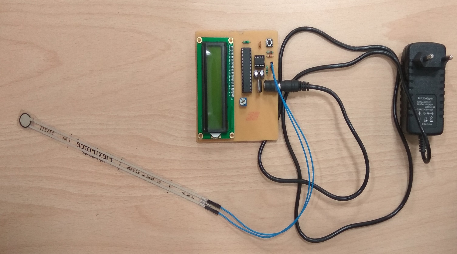 FlexiForce sensor wired to the measurement board with a 12 V power adapter